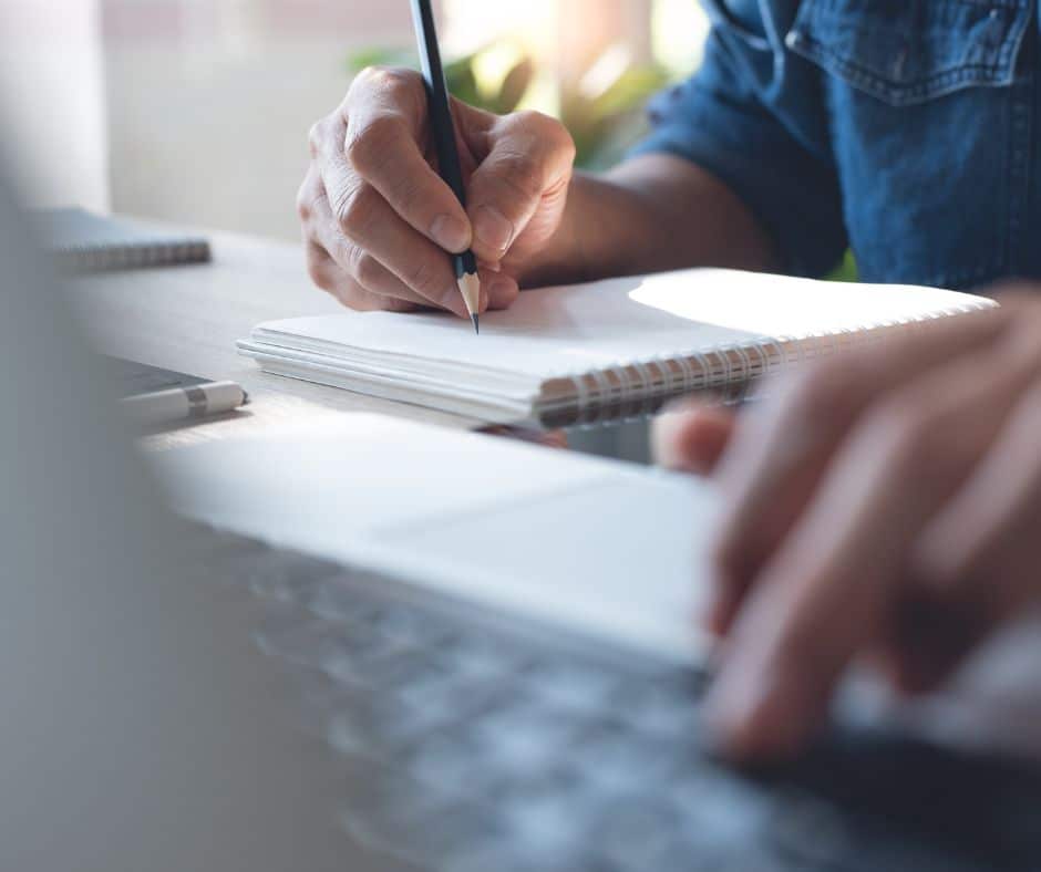 a person writing on a notebook