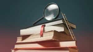 a stack of books with a ladder and a magnifying glass