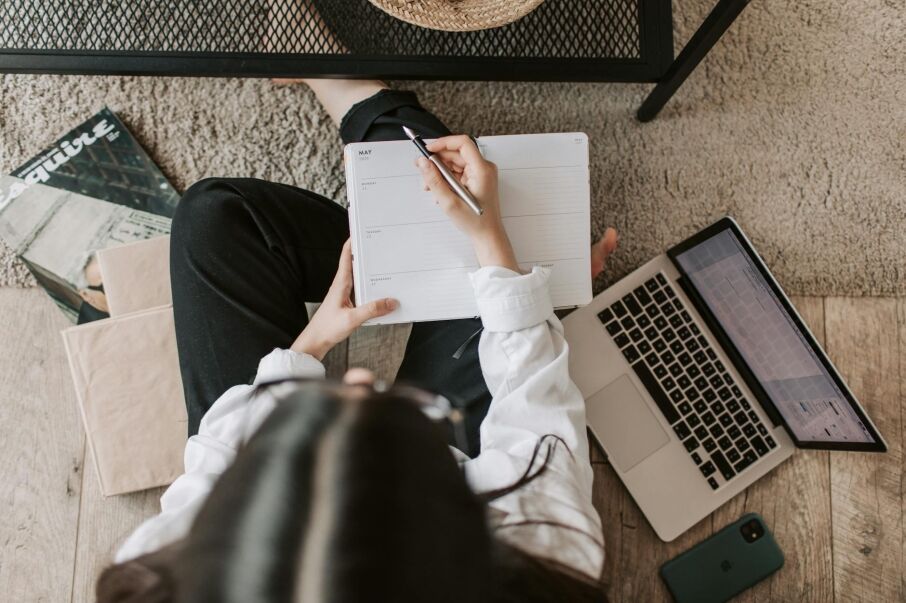 Top view of woman creating plan on notebook