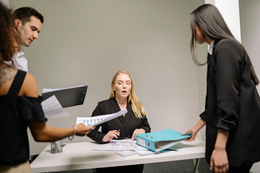 A Woman in Black Blazer Sitting at the Desk with Documents