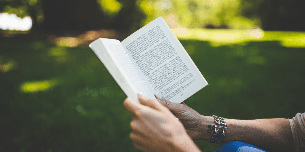 a person reading a book in the park